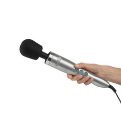 Hand holding the Doxy Die Cast Wand showing ergonomic brushed metal handle and control buttons