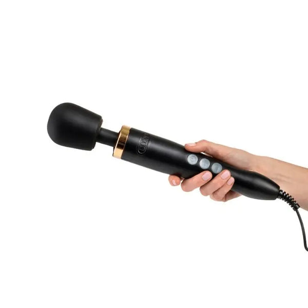 Hand holding the Doxy Die Cast Wand massager, showing ergonomic handle size and corded design