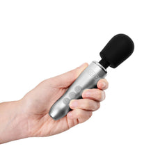 Hand holding the Doxy Go compact wand vibrator, showing silver handle and black silicone head