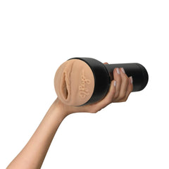 Hand holding Feel Reya masturbator sideways, displaying textured sleeve and black housing