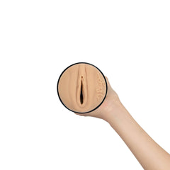 Hand holding Feel Reya stroker cup upright to illustrate compact, palm-sized scale
