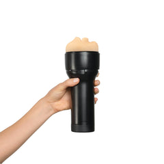 Hand holding Feel Stroker generic mouth masturbator upright, showing compact black cylindrical body