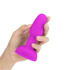 Hand holding fuchsia b-Vibe Rimming Plug Petite to demonstrate compact, palm-friendly size and soft silicone