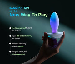 Hand holding illuminated anal plug showing one-touch controls for light colour and vibration mode