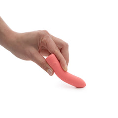 Hand holding ILY The Bullet flexible coral silicone vibrator at a curved angle