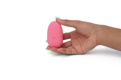 Hand holding ILY Pebble pink silicone vibrator upright, showing compact size