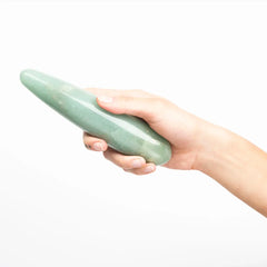 Hand holding the Indian Jade Original Wand, showing its palm-fitting curved body and cool stone texture