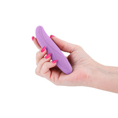Hand holding INYA Flirt purple silicone vibe, showing compact palm-sized scale