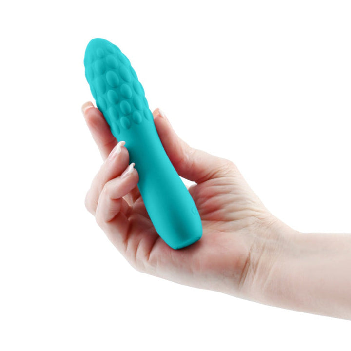 Hand holding the INYA Rita teal silicone vibrator, showing its textured bubble-patterned tip