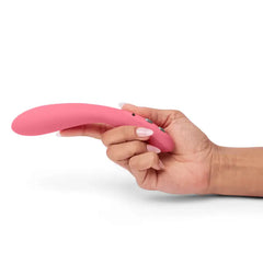 Hand holding the Je Joue ILY Wand vibrator, showing slim ergonomic pink body