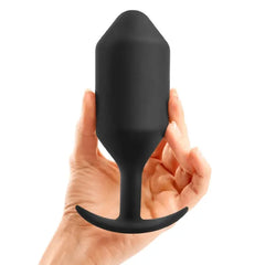 Hand holding large black silicone weighted plug to show scale and overall size