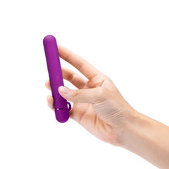 Hand holding Le Wand Baton slim vibrator upright, showing compact ergonomic size