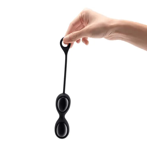 Hand holding Le Wand black obsidian kegel eggs by the silicone loop retrieval cord