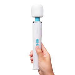 Hand holding Le Wand Classique Petite upright showing compact size and teal control buttons