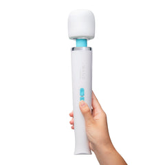 Hand holding Le Wand Classique upright, showing ergonomic handle and two teal control buttons