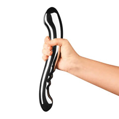 Hand holding Le Wand Contour wand tilted to display ridged handle and curved tip