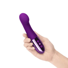 Hand holding Le Wand Gee dark cherry vibrator showing compact ergonomic handle size