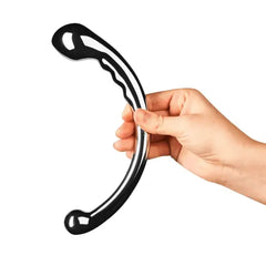 Hand holding Le Wand Hoop stainless steel wand upright, showing full curved length