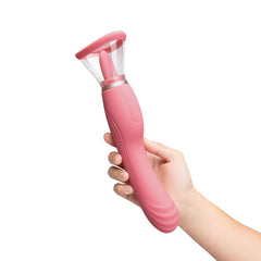 Hand holding Le Wand Lick upright showing ergonomic pink silicone handle and controls