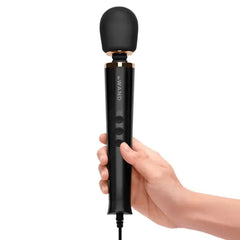 Hand holding Le Wand Petite wand massager showing ergonomic grip and control buttons
