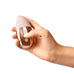 Hand holding Le Wand Point vibrator demonstrating its compact palm-fitting egg shape