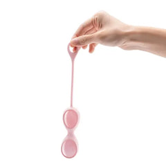 Hand holding LE Wand rose quartz kegel exerciser by its flexible pink silicone loop