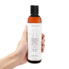 Hand holding Le Wand water-based lubricant bottle showing full label size and ultra-thick gel formula