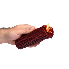 Hand holding lit Master Series Thorn Drip Candle showing deep red paraffin wax texture