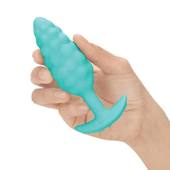 Hand holding mint b-Vibe Bump textured plug to show compact, palm-sized scale