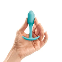 Hand holding mint b-Vibe Snug Plug 1 to illustrate compact, beginner-friendly size