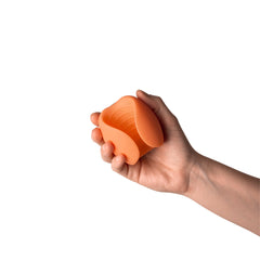 Hand holding the open peach stroker to show compact, palm-sized scale and flexible sides