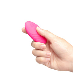 Hand holding the oval remote control to show compact palm-friendly size of the wireless controller
