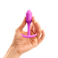 Hand holding pink b-Vibe Snug Plug 1 to show compact beginner-friendly size and scale