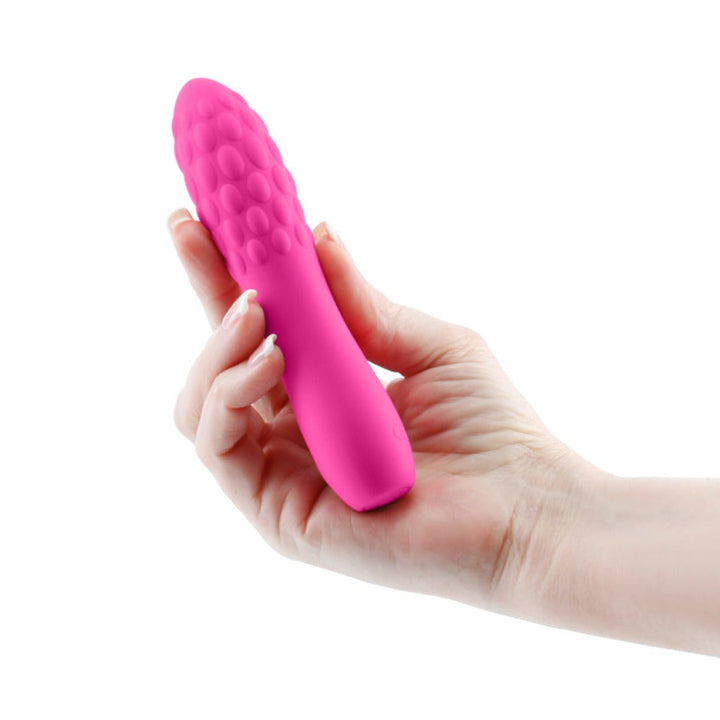 Hand holding pink INYA Rita silicone vibrator showing textured bubble tip and slim handle