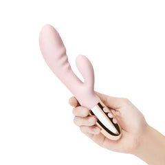 Hand holding pink silicone rabbit vibrator showing compact size and rose gold button controls