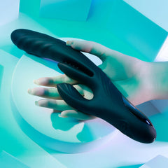 Hand holding the Playboy Rapid Rabbit against teal backdrop, illustrating comfortable grip and size
