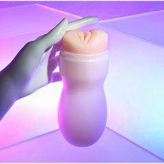 Hand holding Pop & Toss vaginal stroker upright, demonstrating compact, easy-grip canister shape