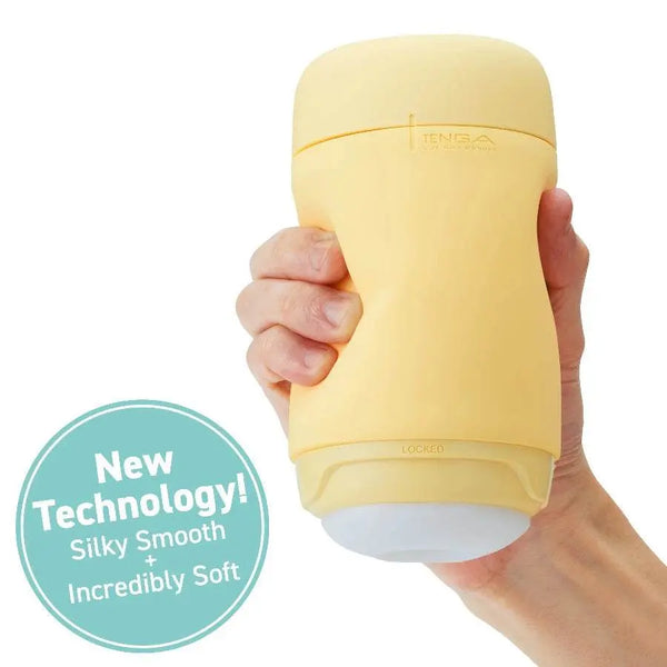 Hand holding PUFFY Custard Yellow masturbator showing palm-sized scale; labelled silky smooth soft material