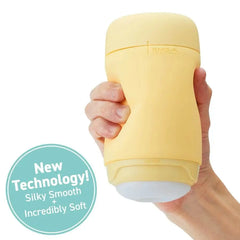 Hand holding PUFFY Custard Yellow masturbator showing palm-sized scale; labelled silky smooth soft material