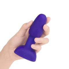 Hand holding purple b-Vibe Rimming Petite Plug to show compact size and soft silicone feel