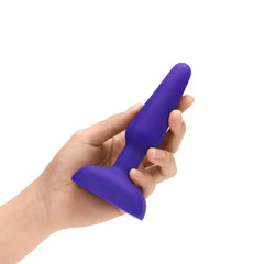 Hand holding purple b-Vibe Trio Plug to show compact, beginner-friendly size and grip