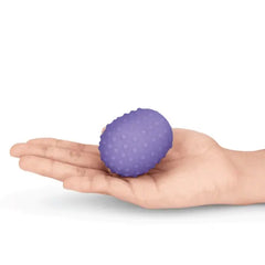 Hand holding a purple dotted silicone texture cover, highlighting the raised nub surface detail