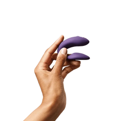 Hand holding purple We-Vibe Chorus couple's vibrator to show compact, palm-fitting size