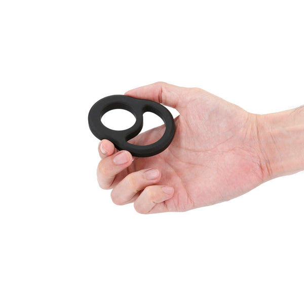 Hand holding Renegade Cradle black dual-loop ring, showing compact, flexible size