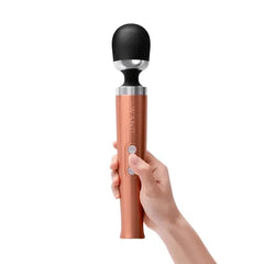 Hand holding the rose gold Le Wand Die Cast Massager upright, demonstrating its ergonomic grip size