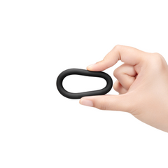 Hand holding single black silicone cock ring pinched to show pliable, body-safe silicone
