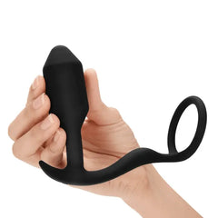 Hand holding Snug & Tug plug upright, showing curved anchor base and ring loop