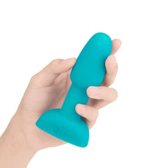 Hand holding teal b-Vibe Rimming Plug Petite to show compact, palm-friendly size