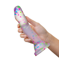 Hand holding the translucent confetti-speckled silicone dildo to show grip and scale