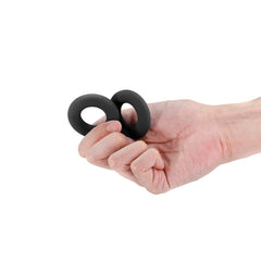 Hand holding two black silicone stretch rings, showing flexible soft material and compact size